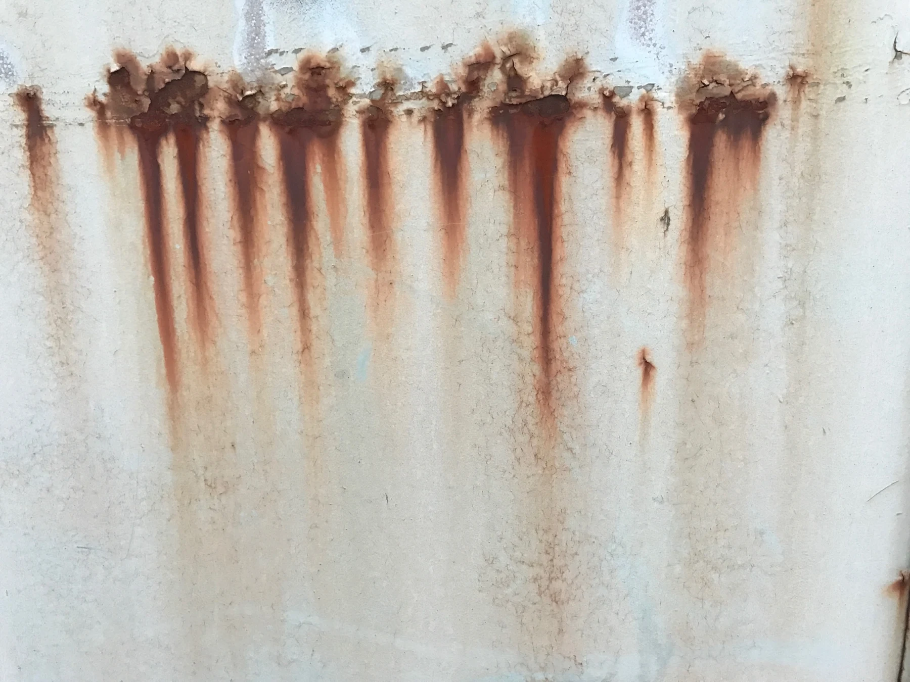 Coulures de rouille sur une surface blanche